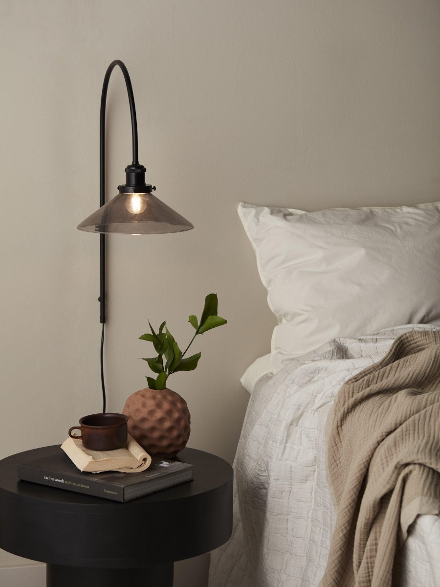 August 25cm Zwart wandlamp Van PR Home - De glazen kap heeft een zwarte afwerking en is bevestigd aan een lampenhouder van zwart geborsteld metaal.