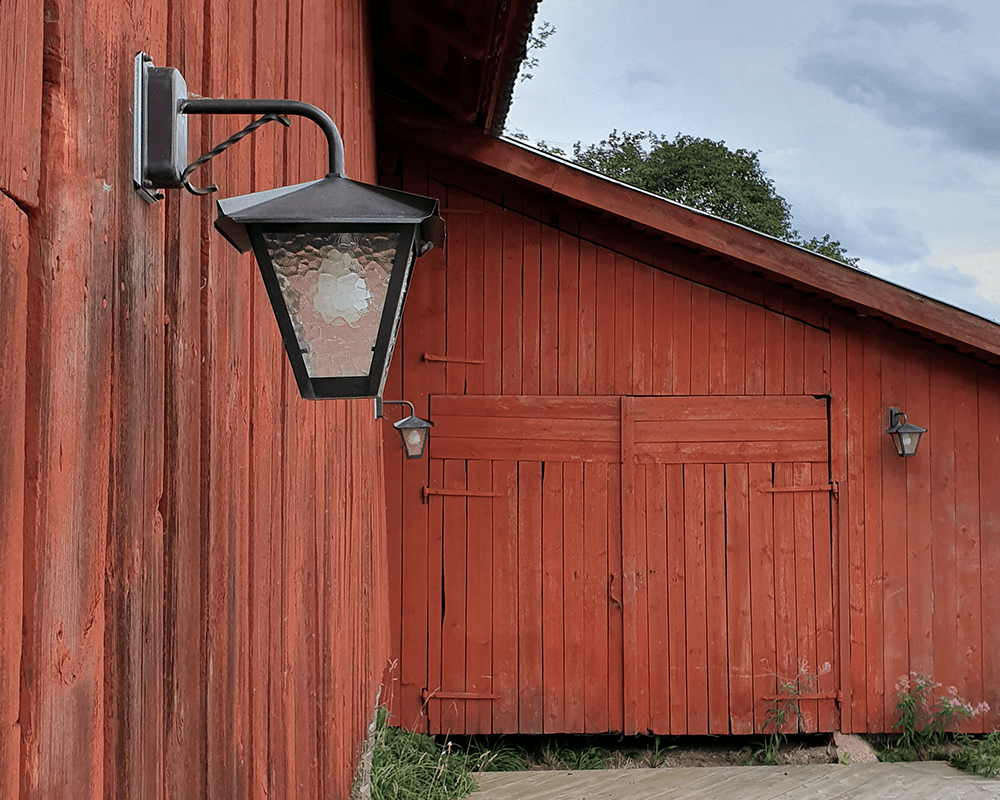 Gustav ned Geoxideerd koper buitenlamp Van Westal - U kunt kiezen uit een naar boven of naar beneden gerichte lantaarn met een gelakte en roestbestendige afwerking of in prachtig geoxideerd koper.