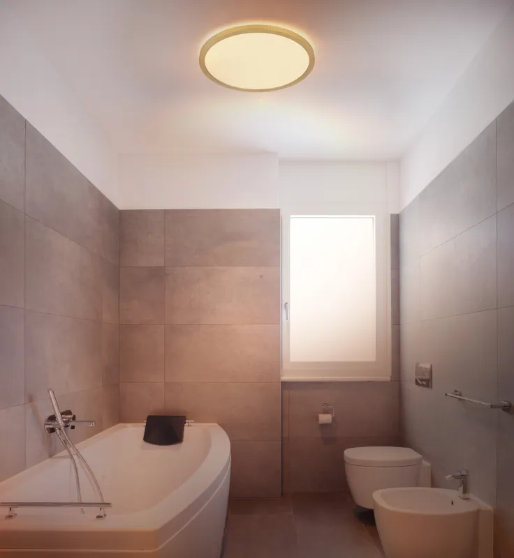 Sapana Ø30 Messing badkamerlamp Van Globo Lighting - Lampan &auml;r tillverkad av matt m&auml;ssingsf&auml;rgad och vit plast, vilket ger ett mjukt och bl&auml;ndfritt ljus.