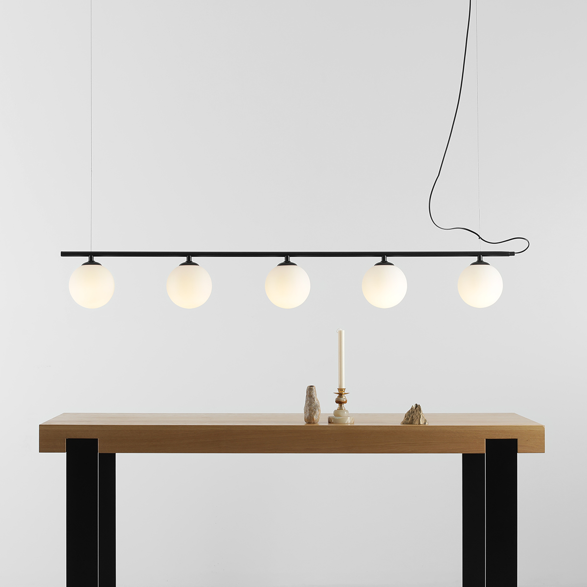 Beryl 140cm Zwart hanglamp Van Artera - De minimalistische zwarte staaf vormt een elegant contrast met de witte bollen en geeft de lamp een moderne en verfijnde uitstraling.