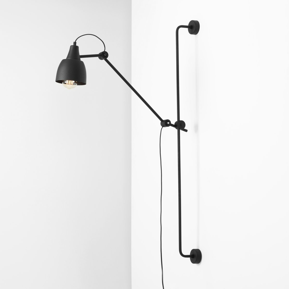 Dron 113cm Zwart wandlamp Van Artera - De matte zwarte afwerking geeft de lamp een industriële en verfijnde uitstraling, terwijl de verstelbare arm maximale flexibiliteit biedt om het licht te richten waar u het nodig hebt.