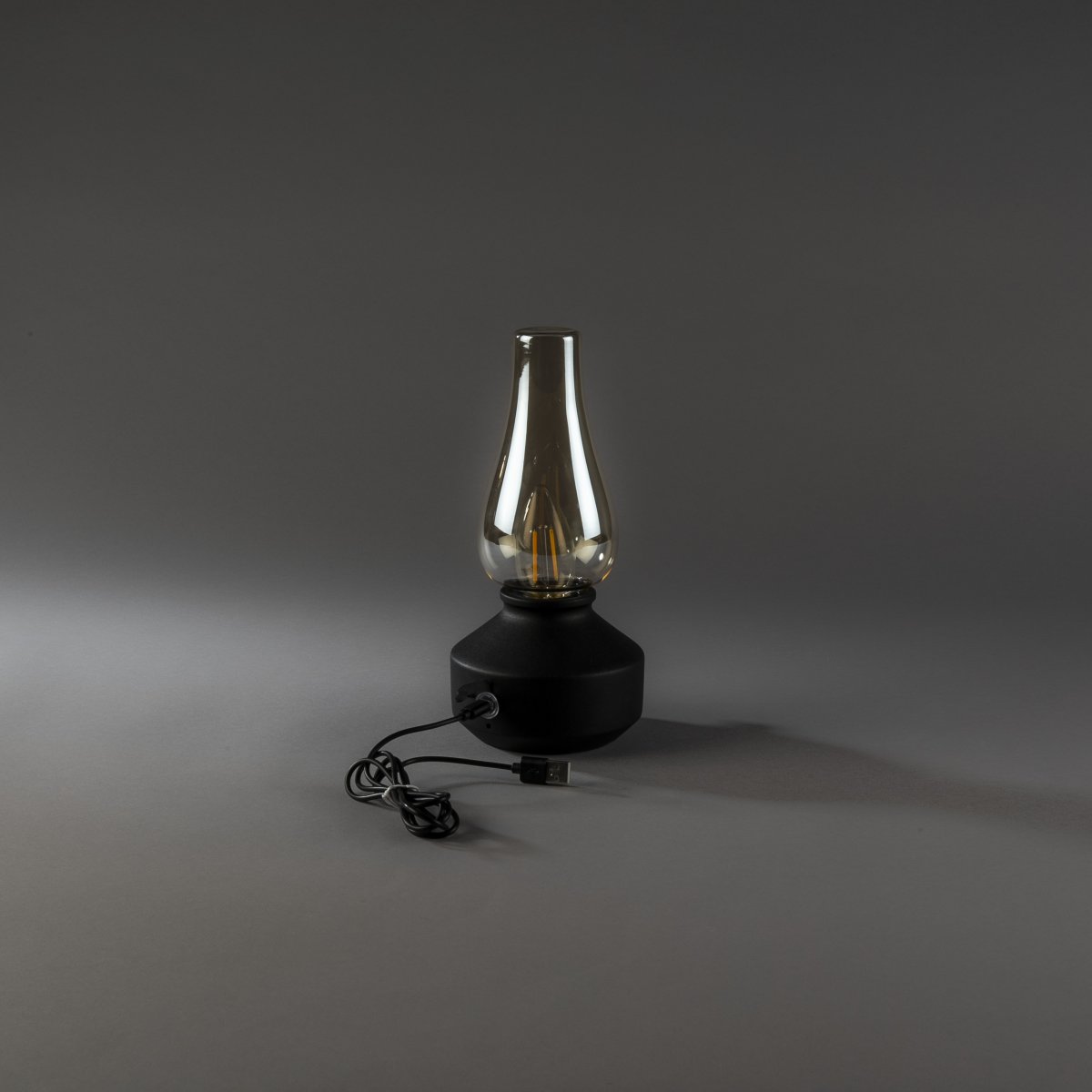Oplaadbare tafellamp 25cm Zwart Draagbare Van Konstsmide - De lamp is gemaakt van metaal en glas met een zwarte voet en een praktische dimmer waarmee het warme, sfeervolle licht eenvoudig kan worden aangepast.