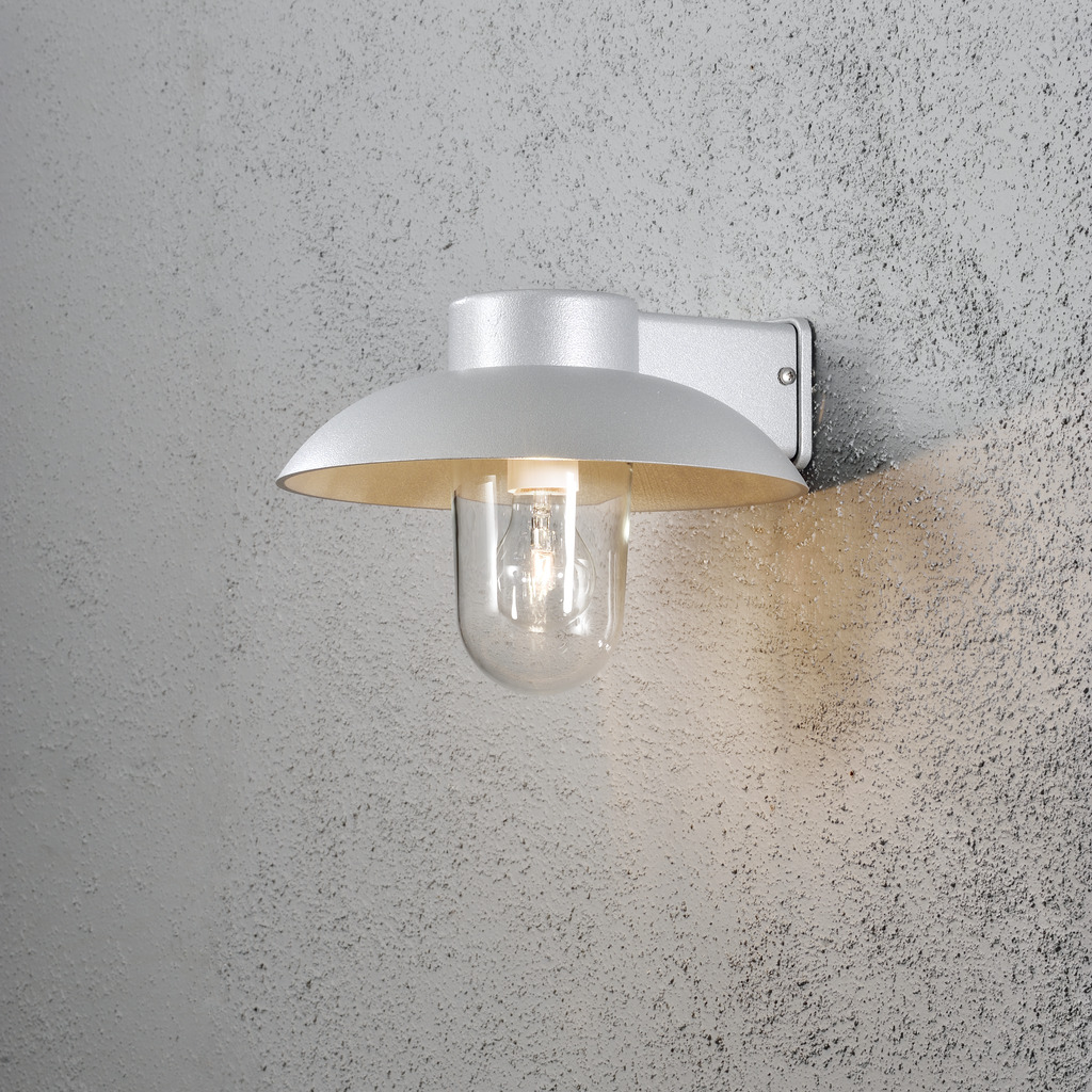 Mani Grijs buitenlamp Van Konstsmide - De brede kap en de heldere glazen koepel verspreiden een aangenaam en gericht licht, waardoor de lamp perfect is voor entrees en terrassen.