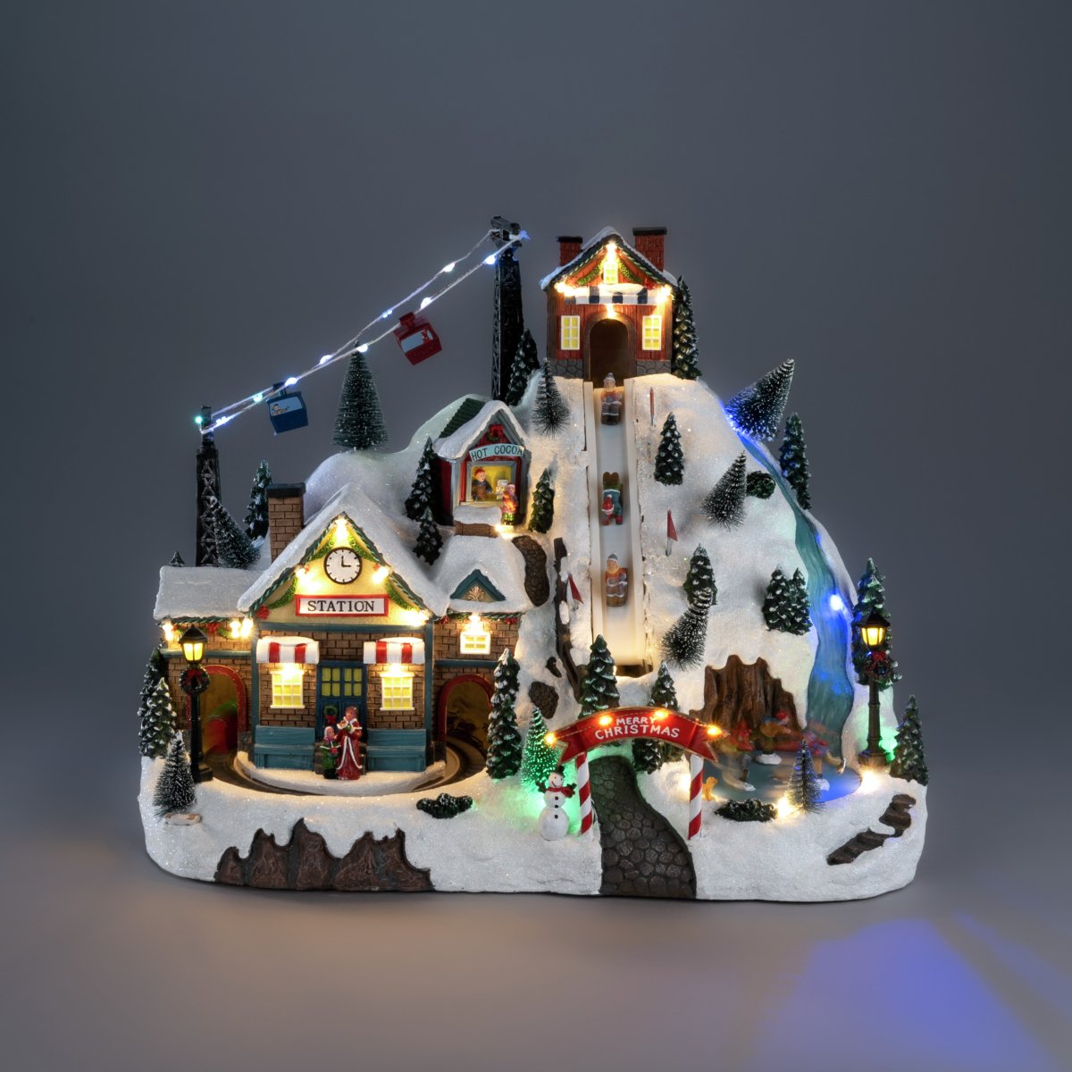 Kerstdorp Skigebied 28cm Veelkleurig Van Konstsmide - Het kerstdorp werkt op 3 AA-batterijen (niet meegeleverd) en wordt geleverd met een USB-kabel voor gebruik met een snoer (transformator niet meegeleverd).