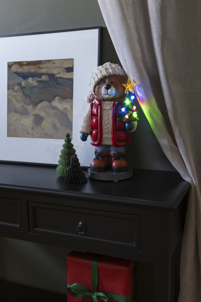 Kleine Teddybeer 38cm Veelkleurig Van Konstsmide - Er staat een felverlichte kerstboom en een lantaarn in, wat voor een gezellige sfeer zorgt.