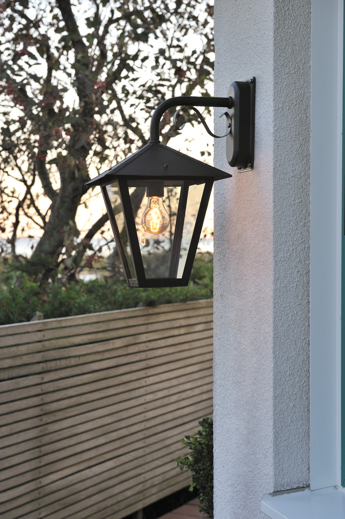 Benu Zwart buitenlamp Van Konstsmide - De klassieke lantaarnvorm en de robuuste materialen van de lamp maken hem tot een perfecte keuze voor wie een uitnodigende sfeer wil cre&euml;ren in entrees of lange gangen.