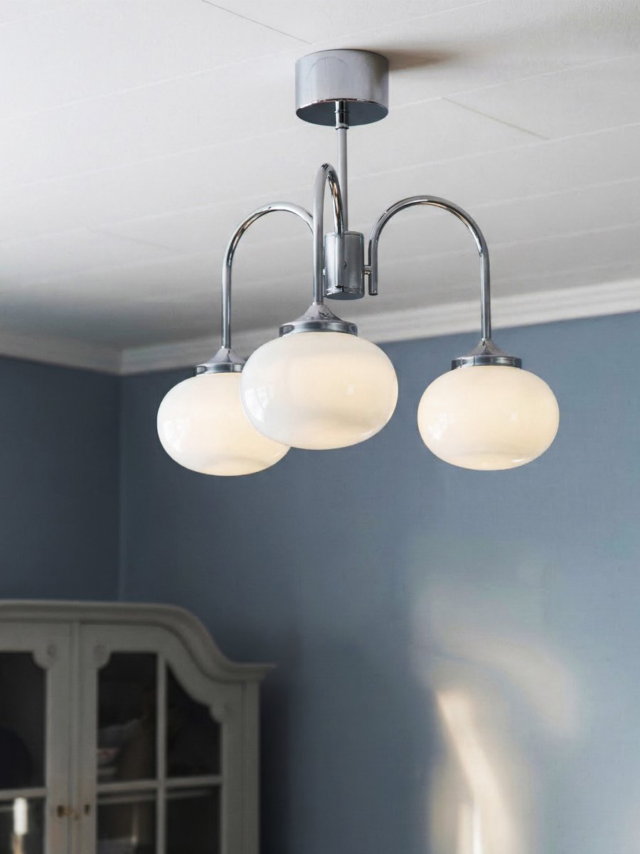 Elsy Ø52 Chroom plafondlamp Van PR Home - De lamp heeft drie naar beneden gerichte armen met witte glazen kappen die een zachte en aangename gloed verspreiden en een gezellige sfeer cre&euml;ren in bijvoorbeeld de woonkamer, eetkamer of hal.