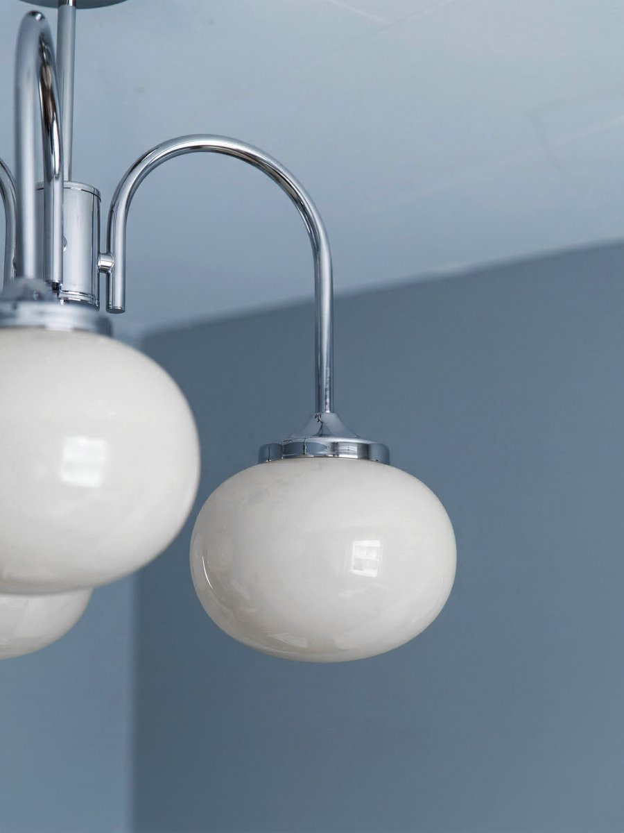 Elsy Ø52 Chroom plafondlamp Van PR Home - De lamp heeft drie naar beneden gerichte armen met witte glazen kappen die een zachte en aangename gloed verspreiden en een gezellige sfeer cre&euml;ren in bijvoorbeeld de woonkamer, eetkamer of hal.