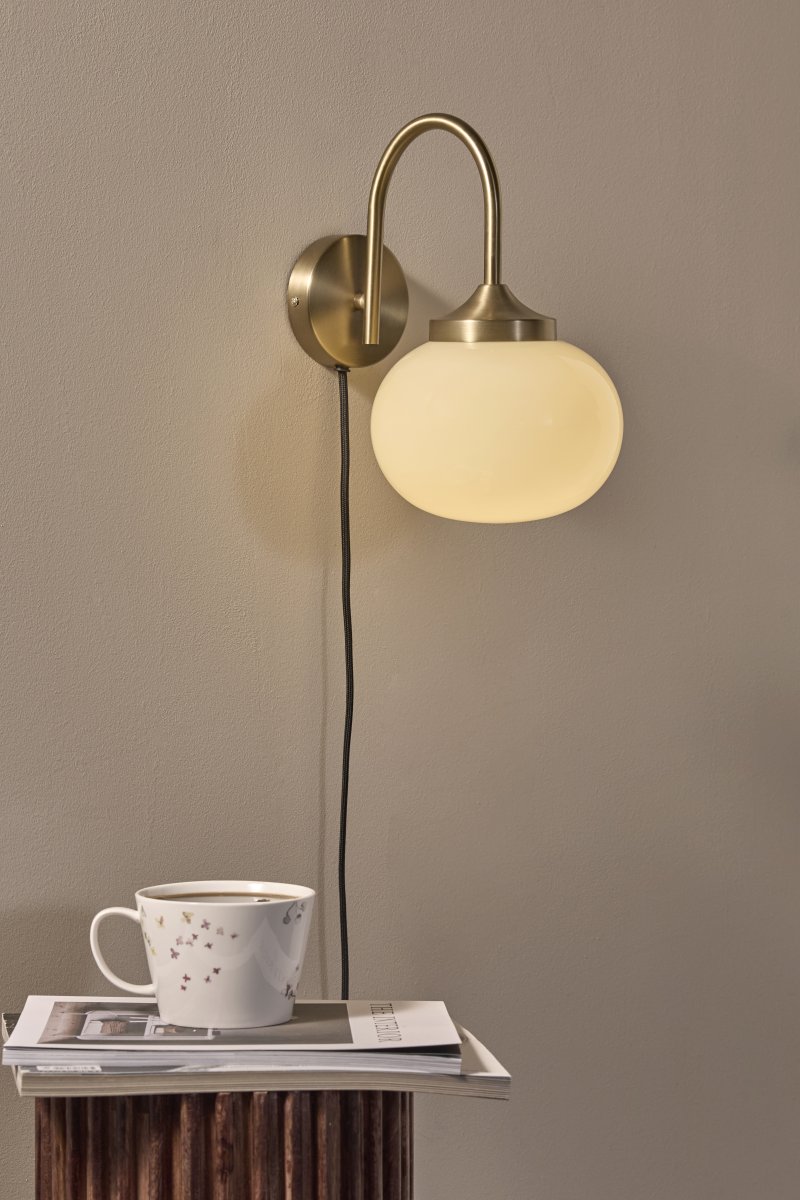 Elsy 30cm Geborsteld messing leeslamp Van PR Home - De handgepolijste glazen kap in een zachte crèmekleurige tint geeft elke lamp een uniek karakter, terwijl de geborstelde messing details een stijlvol en exclusief contrast creëren.