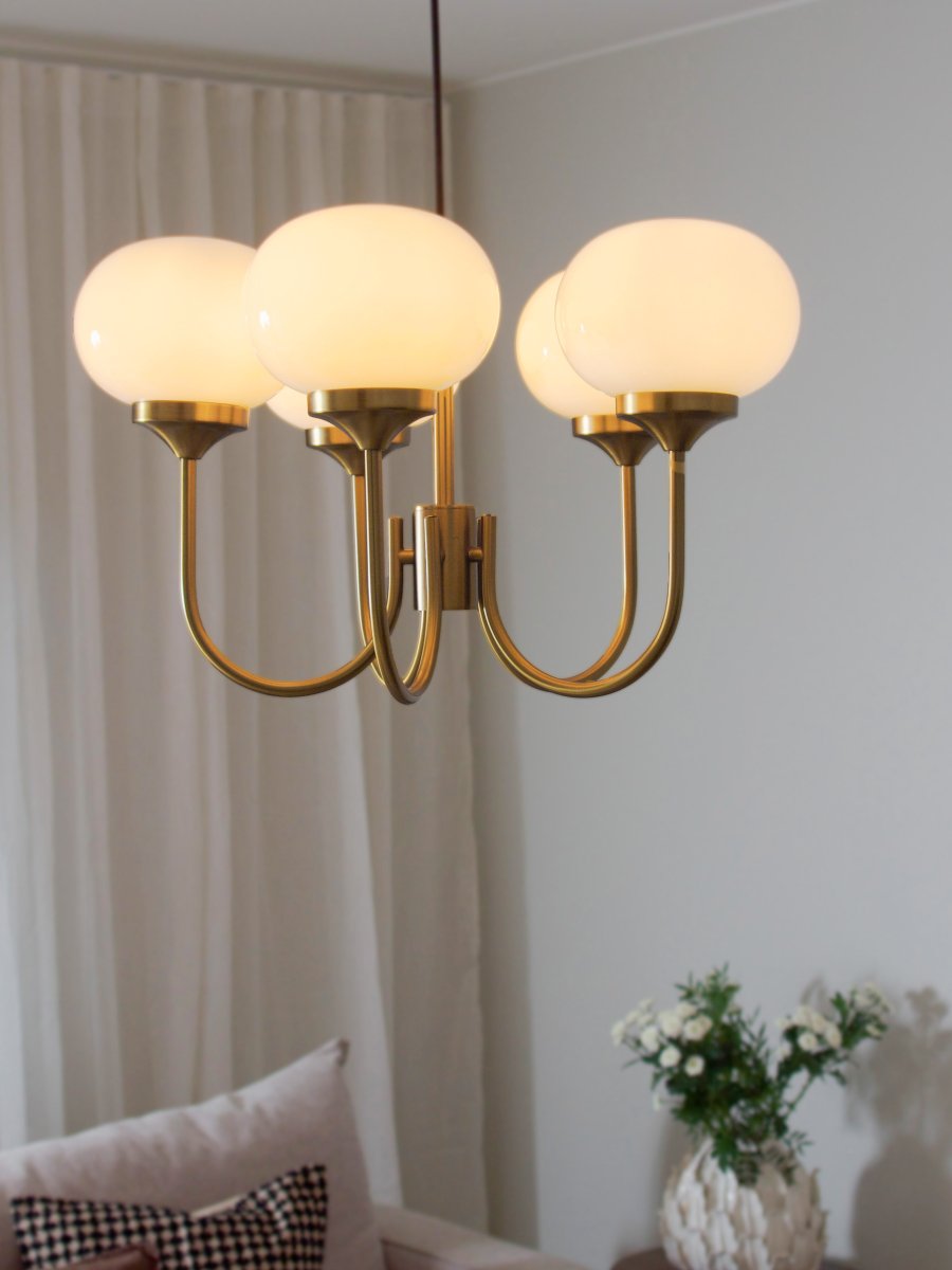 Elsy 5 Ø56 Geborsteld messing hanglamp Van PR Home - De lamp heeft vijf omhoog wijzende armen met crèmekleurige glazen kappen die een zachte en aangename gloed verspreiden en zo een gezellige sfeer creëren in bijvoorbeeld de woonkamer of eetkamer.