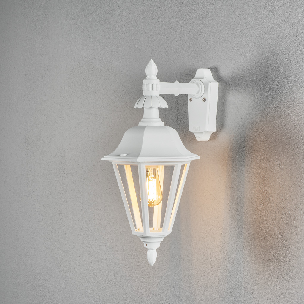 Pallas Wit buitenlamp Van Konstsmide - Dankzij het lantaarnvormige ontwerp en de heldere glaspanelen verspreidt de lamp een warm en uitnodigend licht dat perfect is voor entrees, terrassen en looppaden.