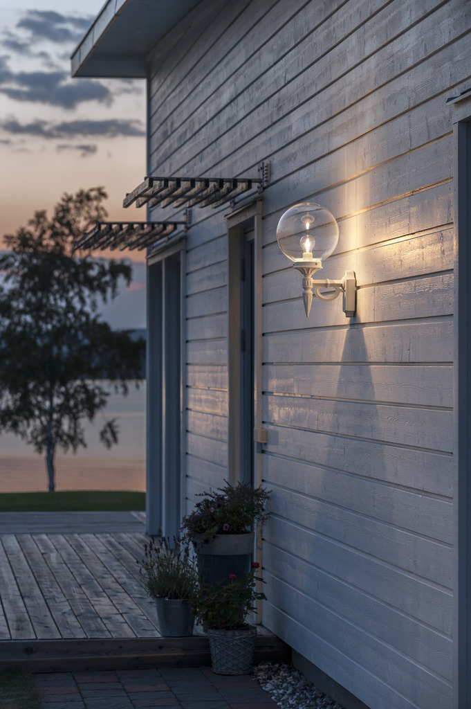 Orion Wit buitenlamp Van Konstsmide - Met zijn decoratieve details en tijdloze stijl wordt deze wandlamp een elegant detail dat uw gevel verfraait en een uitnodigende sfeer creëert.