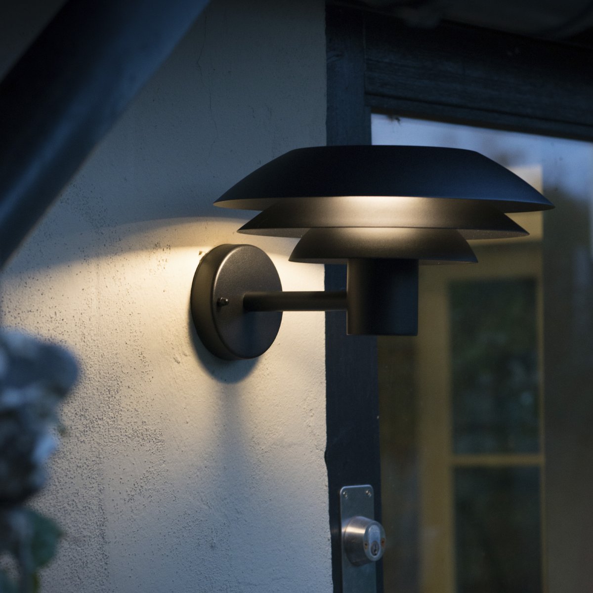DL31 Zwart buitenlamp Van Dyberg Larsen - De DL31 gevellamp uit de DL-serie van Dyberg Larsen zorgt voor fantastische verlichting rondom uw huis met de iconische drie kappen in verschillende maten die een magisch licht verspreiden.