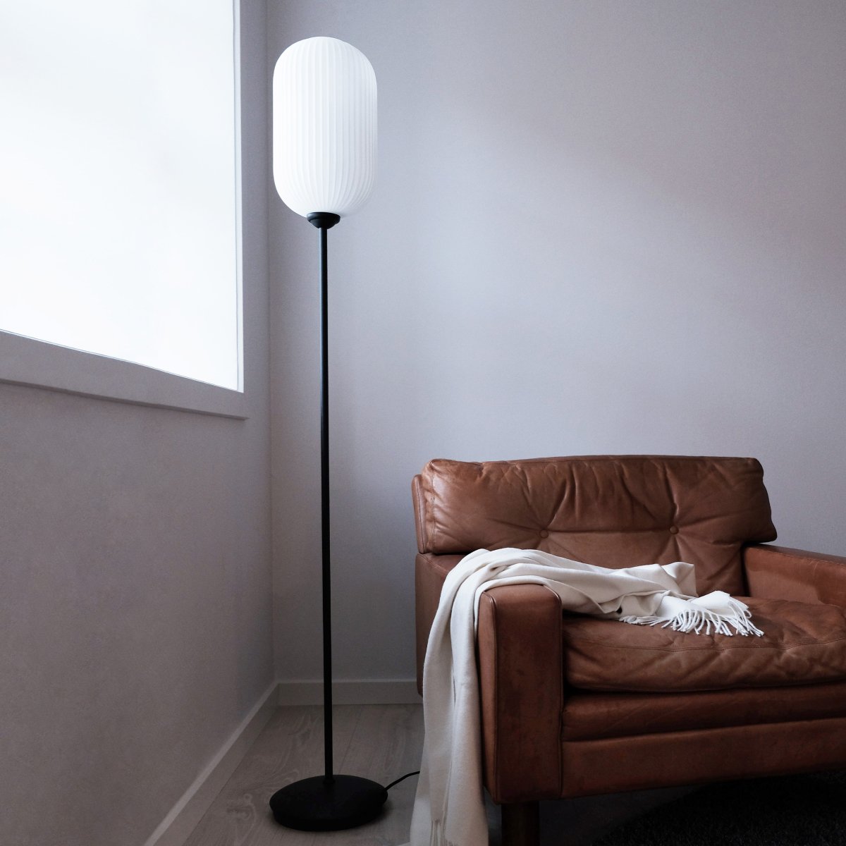 Riflet Zwart vloerlamp Van Dyberg Larsen - De Riflet vloerlamp van Dyberg Larsen heeft een nieuw design met een prachtig gecanneleerde lampenkap van opaalglas die een zacht en aangenaam licht verspreidt.