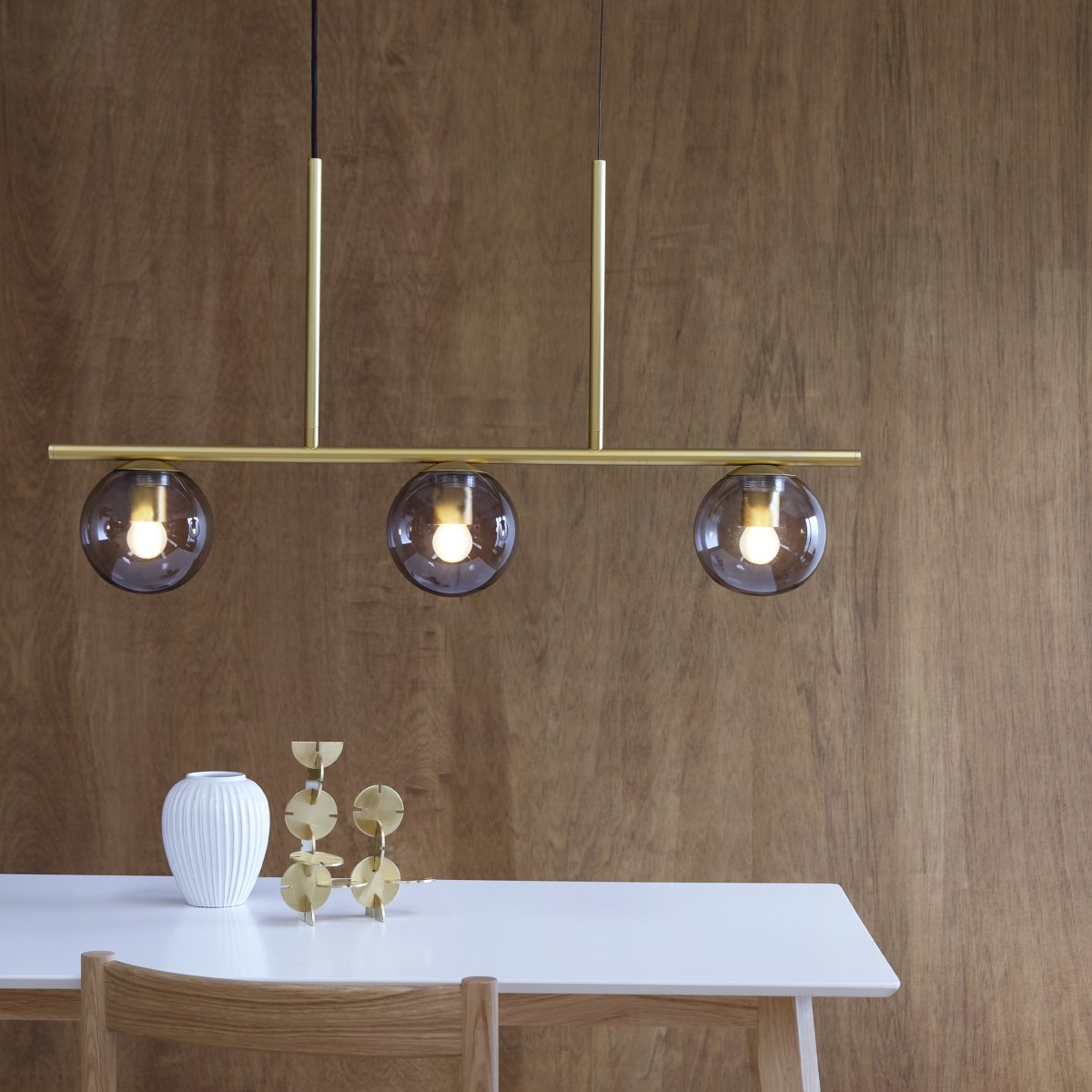 Sophia 90cm Messing hanglamp Van Dyberg Larsen - De Sophia hanglamp in messing met drie kappen van gerookt glas is een elegante plafondlamp voor aan de eettafel of in de keuken, waar een verfijnde toets gewenst is.