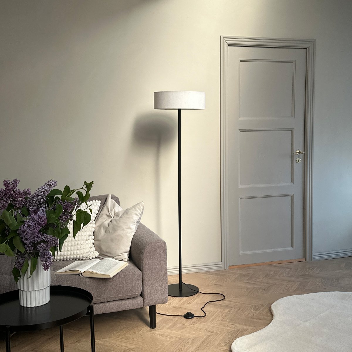 Calix Zwart vloerlamp Van Dyberg Larsen - Dankzij de stabiele basis en de eenvoudige vorm is deze lamp eenvoudig te plaatsen in verschillende omgevingen, terwijl hij tegelijkertijd sfeerverlichting biedt en een elegant designelement is.