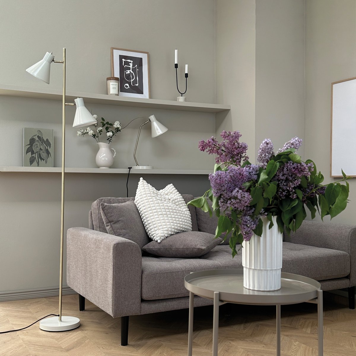 Sleep Glanzend wit vloerlamp Van Dyberg Larsen - De witte kleur geeft de lamp een moderne en strakke uitstraling die past bij verschillende interieurstijlen, terwijl de antieke messing details een elegante toets toevoegen.
