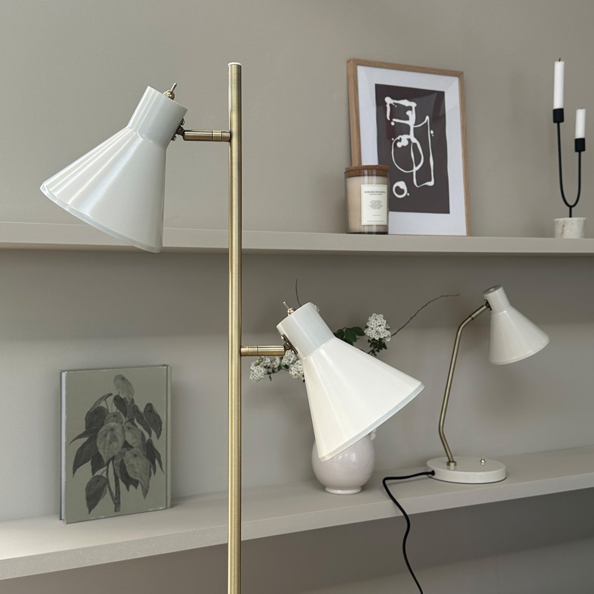 Sleep Glanzend wit vloerlamp Van Dyberg Larsen - De witte kleur geeft de lamp een moderne en strakke uitstraling die past bij verschillende interieurstijlen, terwijl de antieke messing details een elegante toets toevoegen.