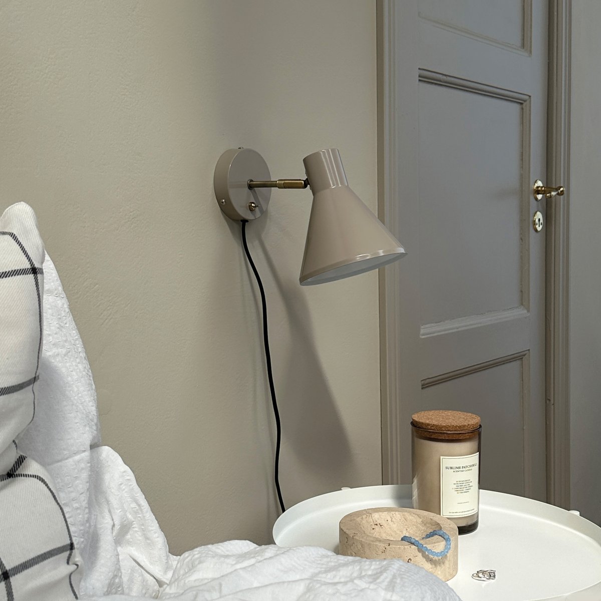 Sleep Glanzend beige leeslamp Van Dyberg Larsen - De beige kleur cre&euml;ert een strakke en rustige sfeer, terwijl de antieke messing details een extra niveau van verfijning toevoegen.