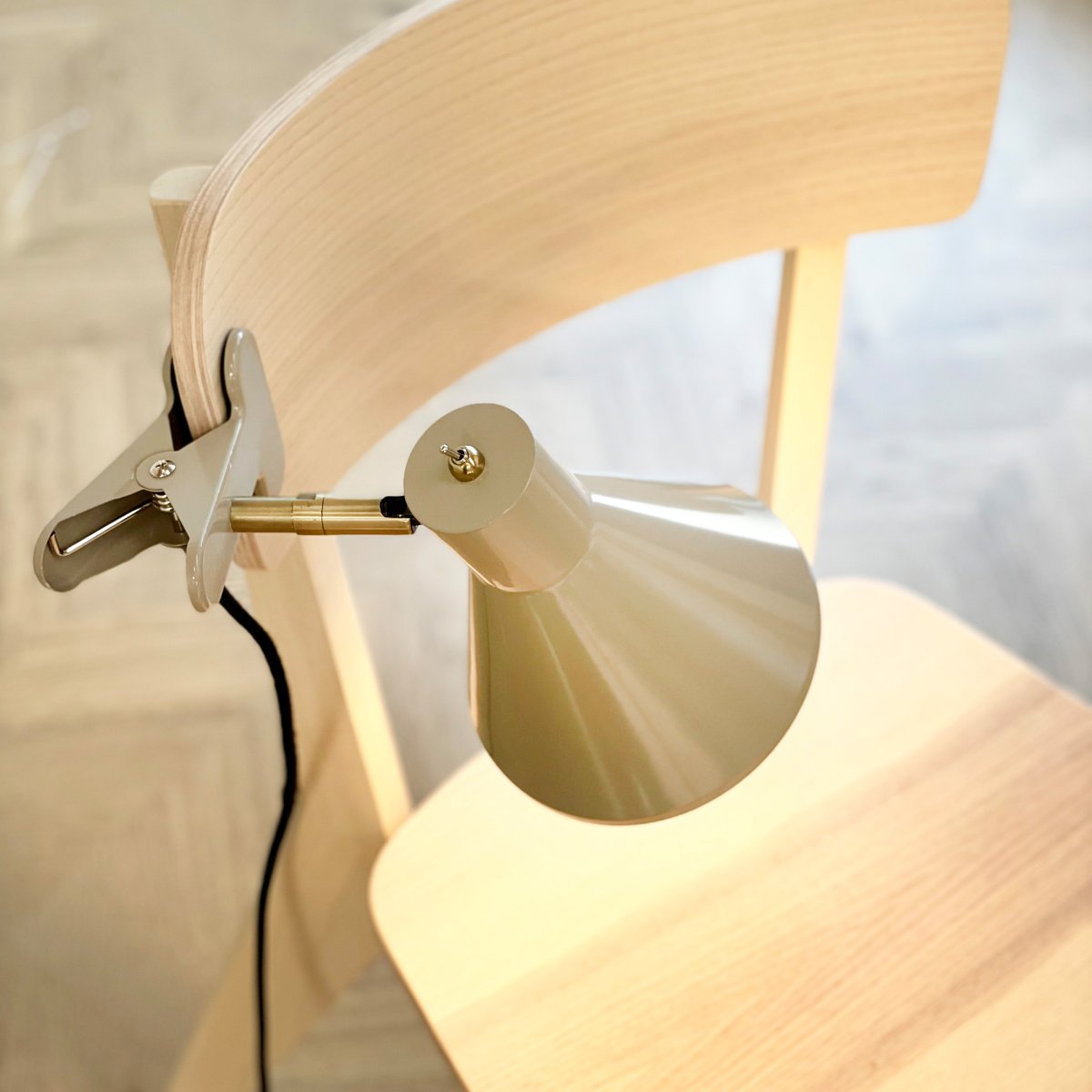 Sleep Glanzend beige klemlamp Van Dyberg Larsen - De beige kleur zorgt voor een strakke en rustige uitstraling, terwijl de antieke messing details een elegante uitstraling toevoegen.