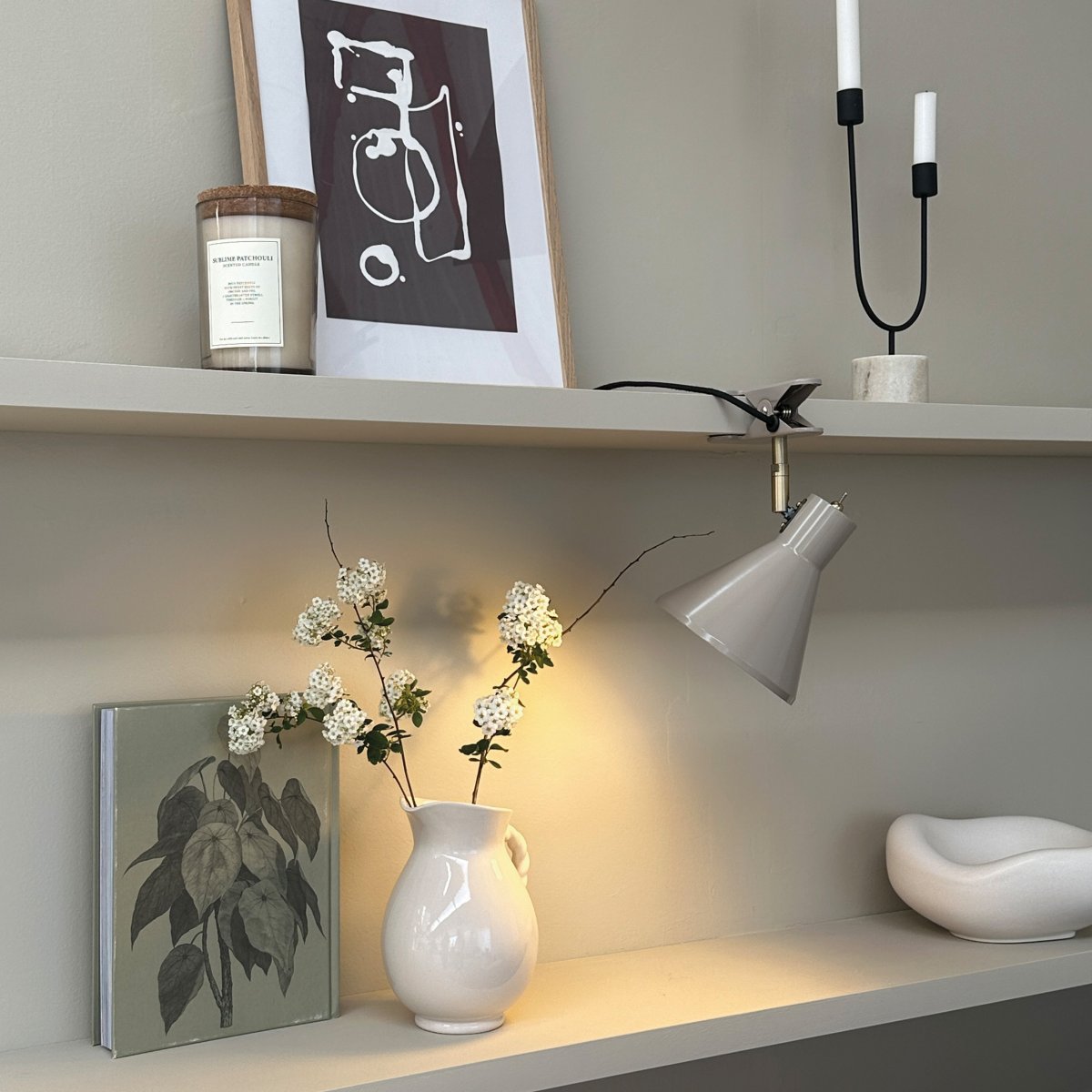 Sleep Glanzend beige klemlamp Van Dyberg Larsen - De beige kleur zorgt voor een strakke en rustige uitstraling, terwijl de antieke messing details een elegante uitstraling toevoegen.