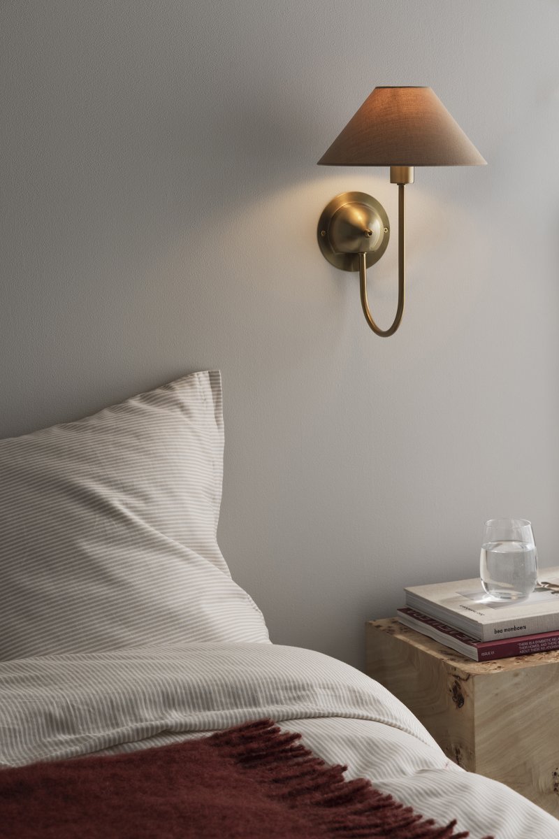 Iris 32cm Messing/bruin wandlamp Van Globen Lighting - De zacht gebogen arm is gecombineerd met een bruine textielen kap, wat zorgt voor een warme en klassieke uitstraling.