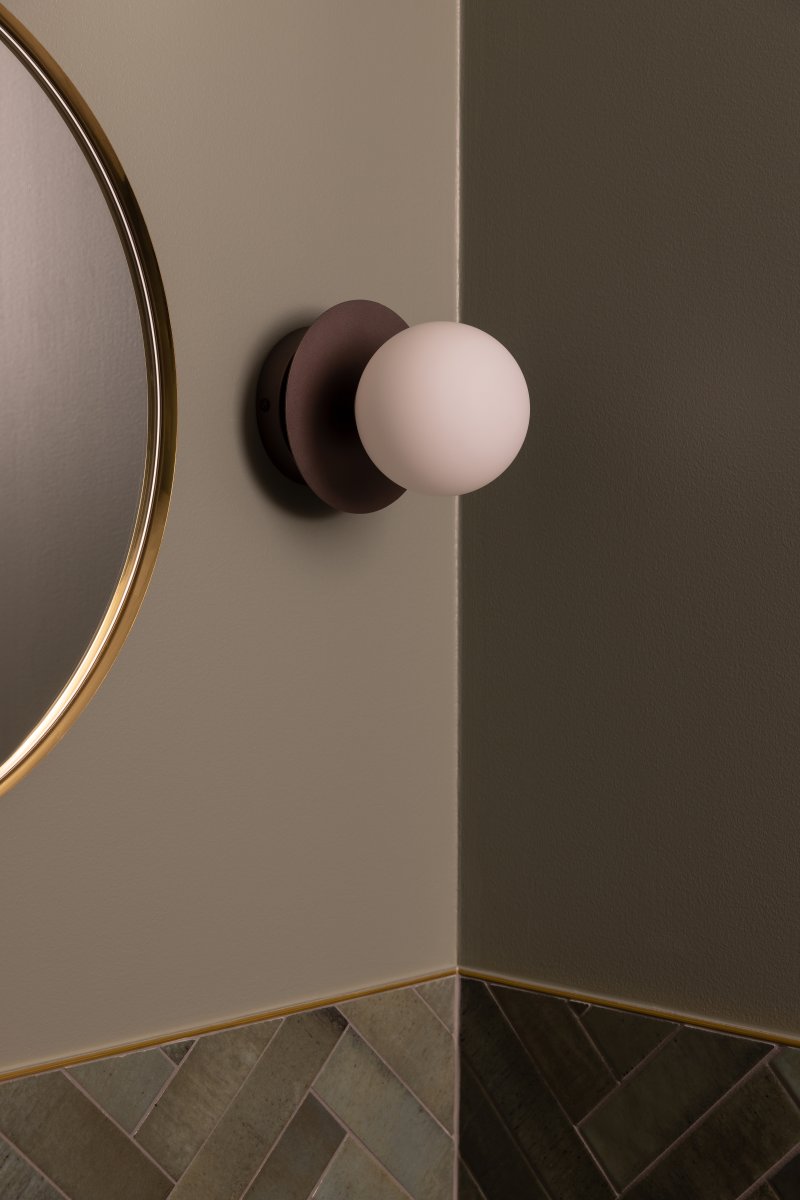 Art Deco Ø16 Brons/wit badkamerlamp Van Globen Lighting - De lamp is gemaakt van metaal en heeft een witte glazen kap die zorgt voor een mooie lichtspreiding in de kamer.
