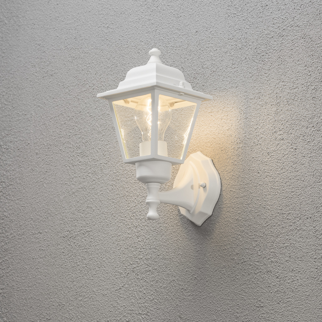 Vägglykta Wit buitenlamp Van Konstsmide - Dankzij het lantaarnvormige ontwerp en de heldere glaspanelen verspreidt de lamp een warm en uitnodigend licht dat perfect is voor entrees, terrassen en looppaden.