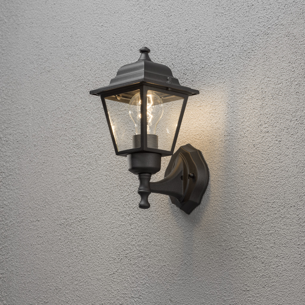 Vägglykta Zwart buitenlamp Van Konstsmide - Dankzij het lantaarnvormige ontwerp en de heldere glaspanelen verspreidt de lamp een warm en uitnodigend licht dat perfect is voor entrees, terrassen en looppaden.