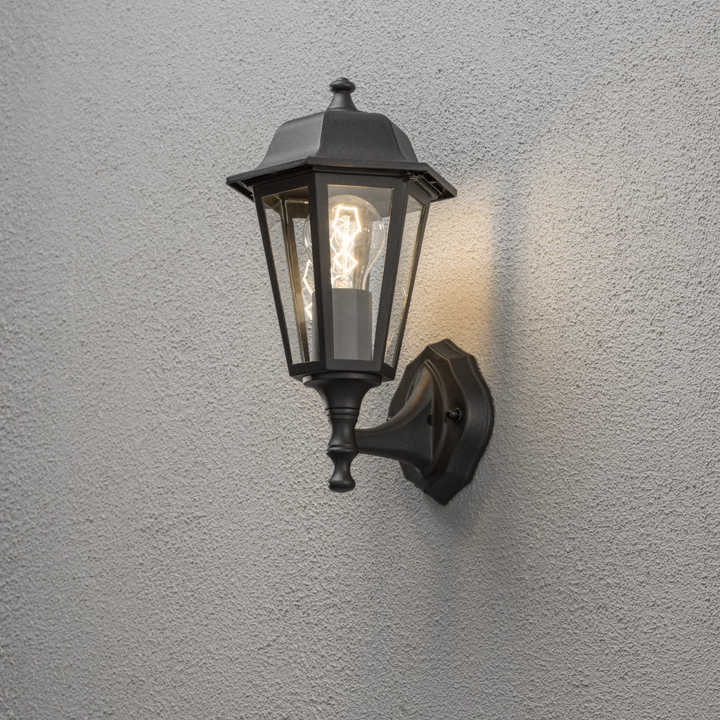 Vägglykta Zwart buitenlamp Van Konstsmide - Dankzij het lantaarnvormige ontwerp en de heldere glaspanelen verspreidt de lamp een warm en uitnodigend licht dat perfect is voor entrees, terrassen en looppaden.