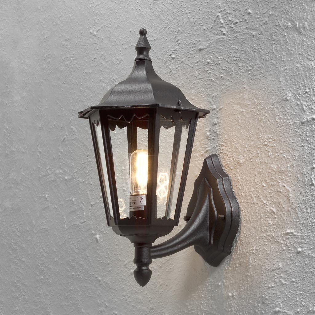 Firenze Zwart buitenlamp Van Konstsmide - Het elegante design en het warme licht van de lamp creëren een uitnodigende sfeer die perfect is voor entrees en terrassen.