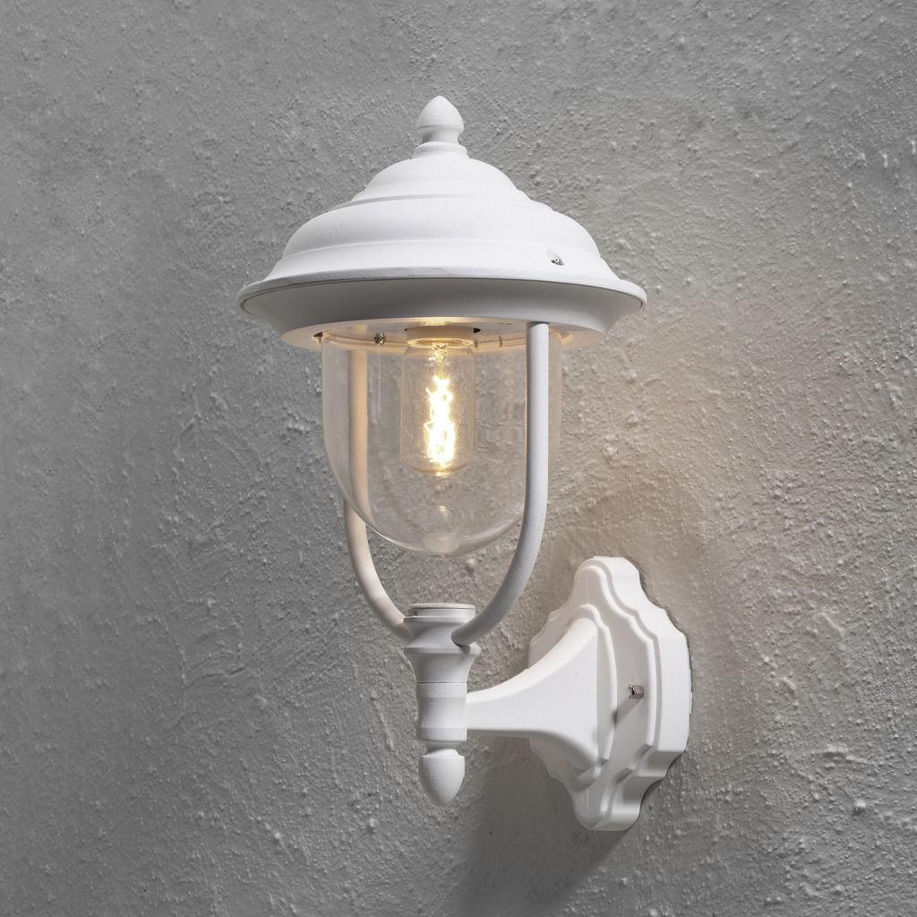 Parma Wit buitenlamp Van Konstsmide - Dankzij de mooie vorm en de heldere glazen kap verspreidt de lamp een warm en uitnodigend licht, ideaal voor entrees en terrassen.