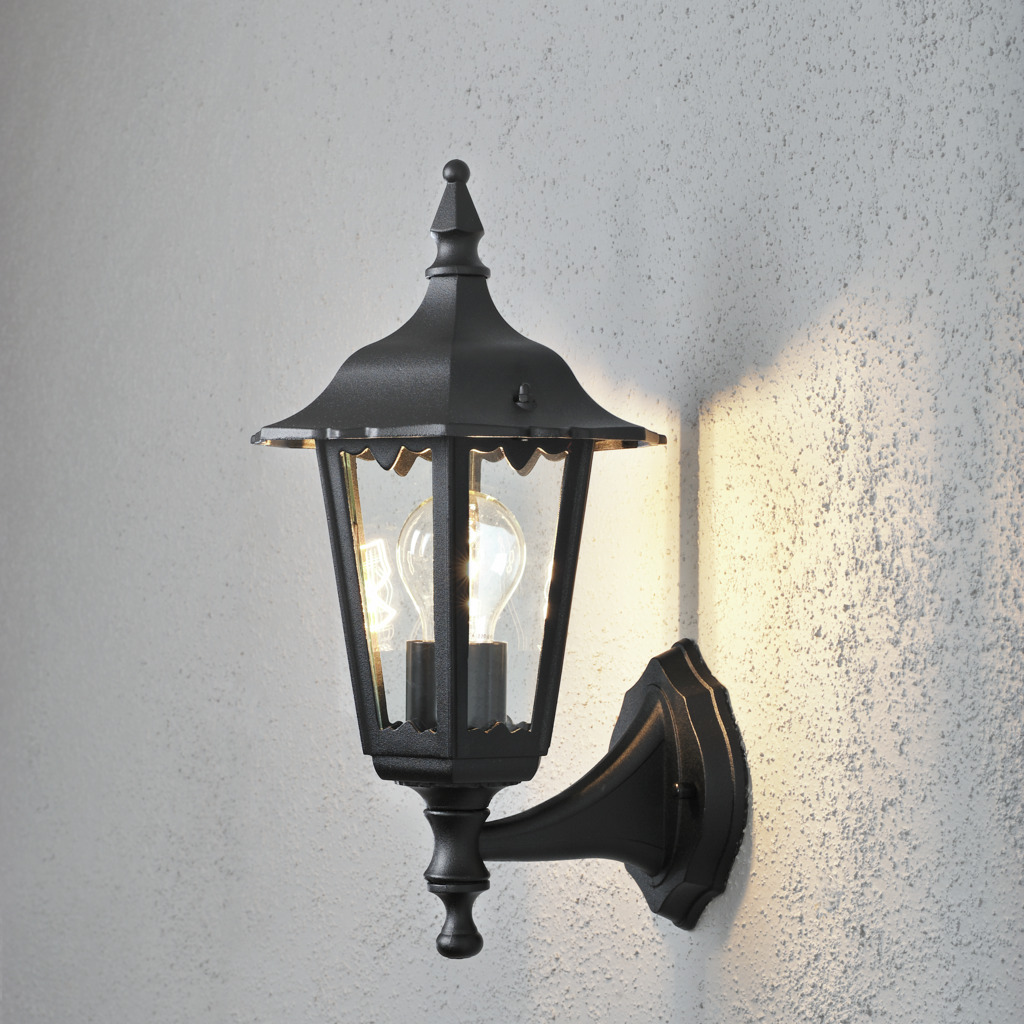 Firenze Zwart buitenlamp Van Konstsmide - Het elegante design en het warme licht van de lamp creëren een uitnodigende sfeer die perfect is voor entrees en terrassen.