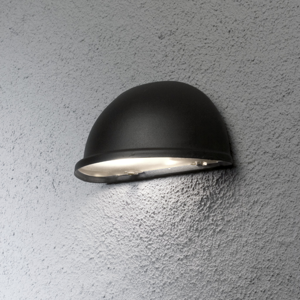 Torino Zwart buitenlamp Van Konstsmide - De matte zwarte afwerking en minimalistische halvemaanvorm zorgen voor een subtiel en aangenaam licht dat perfect is voor terrassen, looppaden en ingangen.