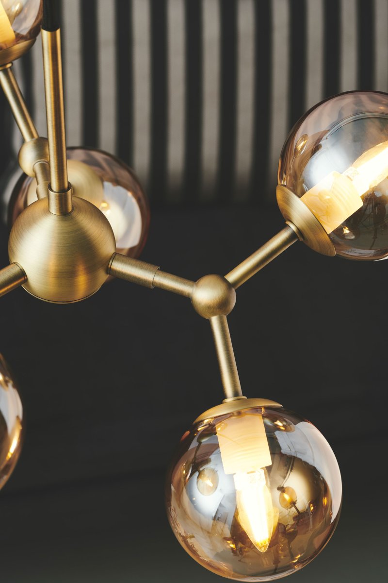 Atom 45cm Antiek messing hanglamp Van Halo Design - De bijna zwevende glazen koepels zijn amberkleurig, waardoor er een mooie lichtspreiding in de ruimte ontstaat.