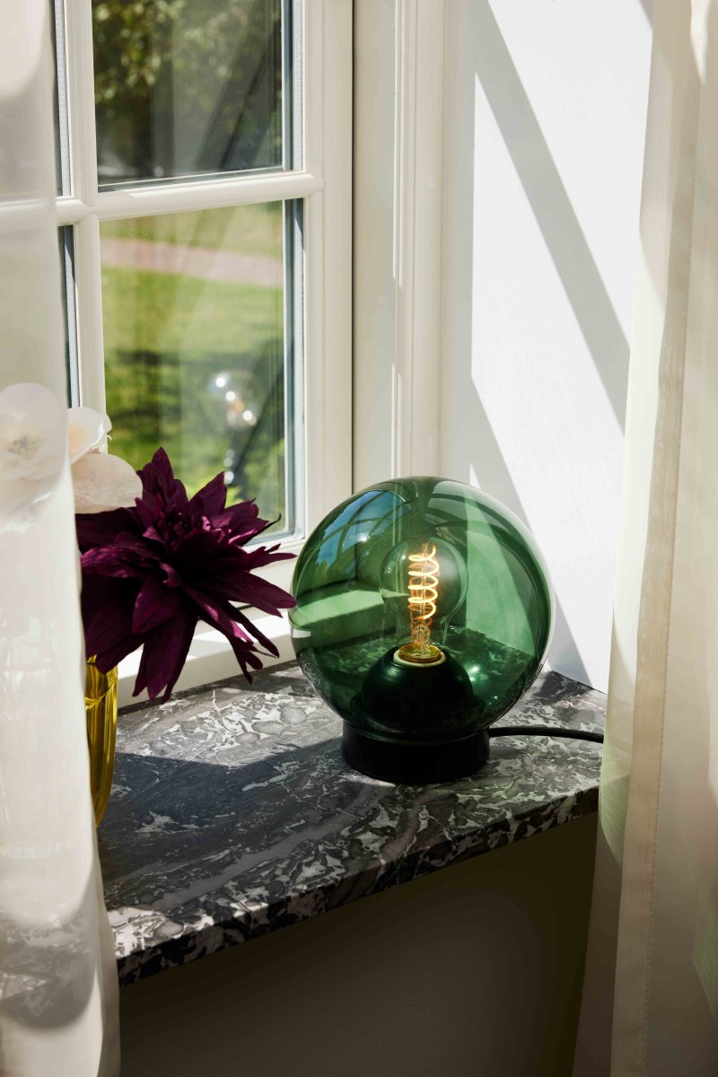 Bubbles 20cm Groente tafellamp Van Halo Design - Het groene glas in combinatie met de matzwarte metalen details voegt elegantie toe en zorgt voor een mooie lichtspreiding in de kamer wanneer de lamp aan staat.