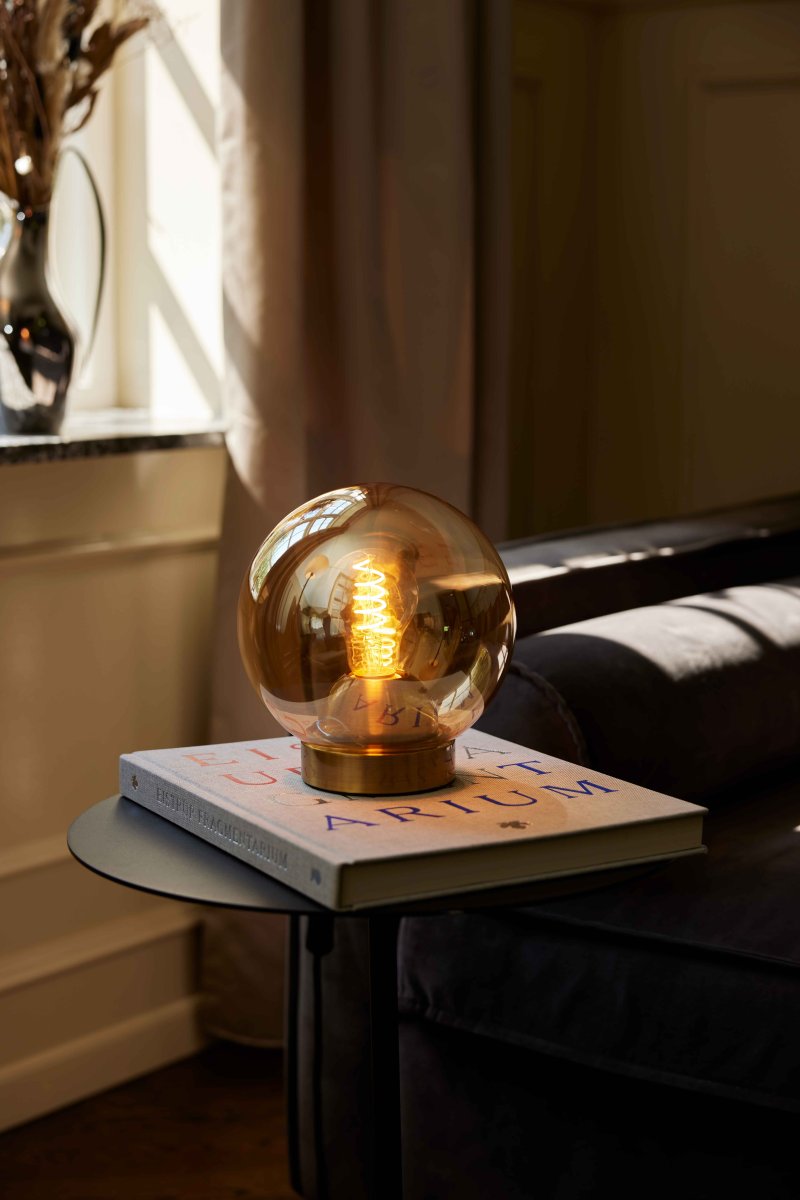 Bubbles 20cm Amber tafellamp Van Halo Design - Het amberkleurige glas in combinatie met de antieke messing details voegt elegantie toe en zorgt voor een mooie lichtverspreiding in de kamer wanneer de lamp aan staat.