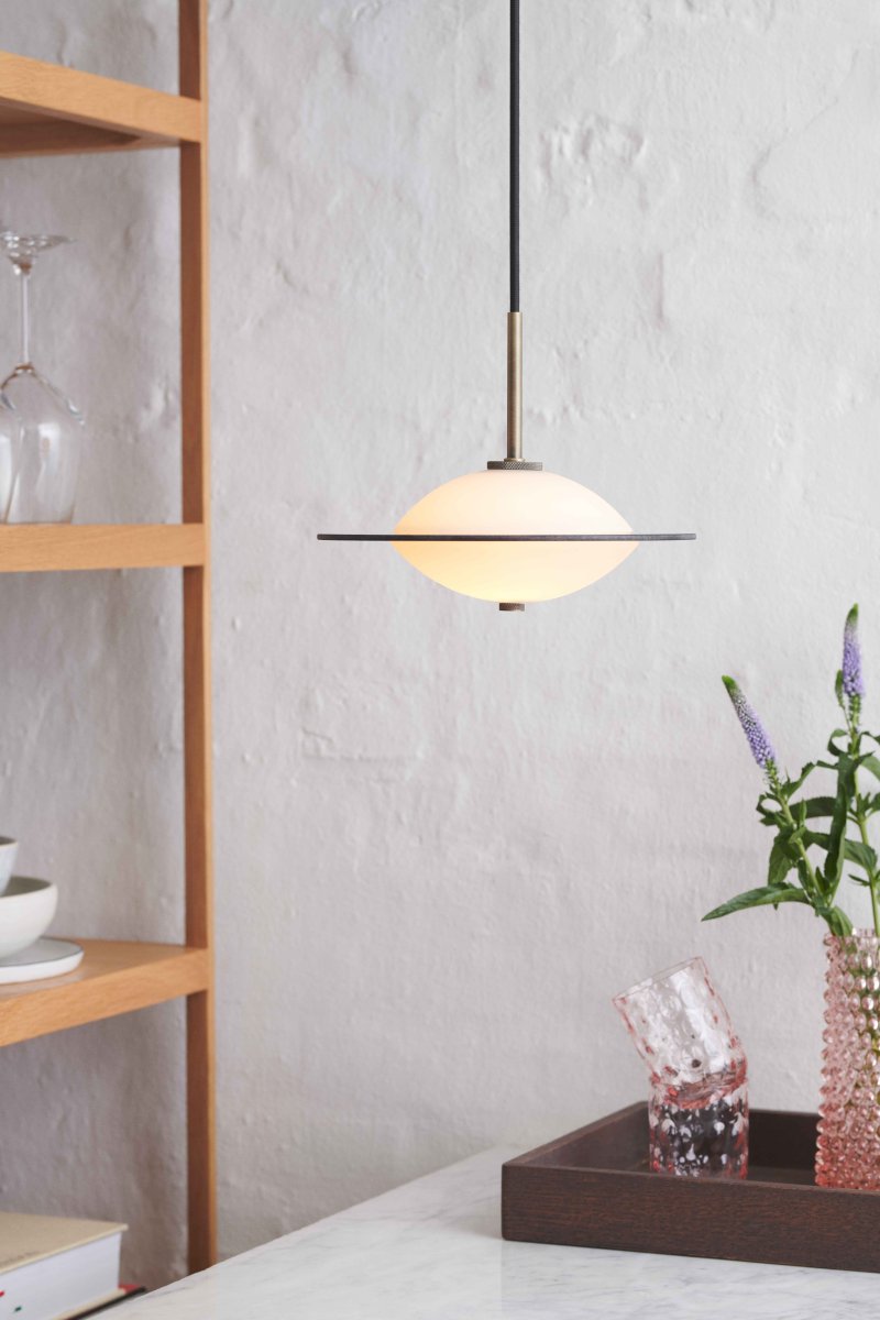 Orbit Ø24 Antiquiteit hanglamp Van Halo Design - De ronde vorm van opaalglas zorgt voor een zacht en sfeervol licht, terwijl de details in antiek messing en amberkleurig glas een warme en verfijnde toets toevoegen.