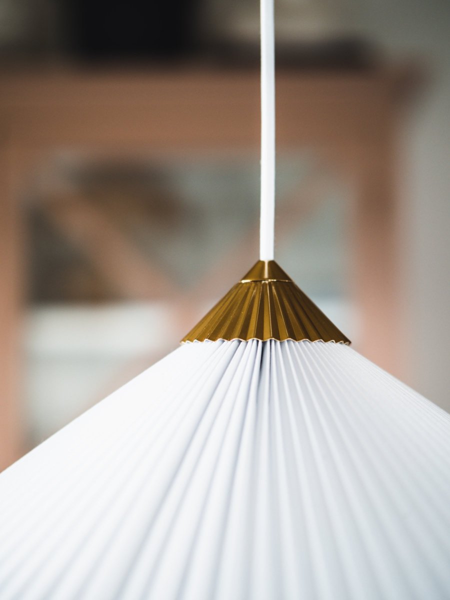 Matisse Ø60 Wit hanglamp Van Globen Lighting - De lamp heeft een geplooide witte textielen kap en is versierd met een bijpassende geplooide bovenkant van messingkleurig metaal.