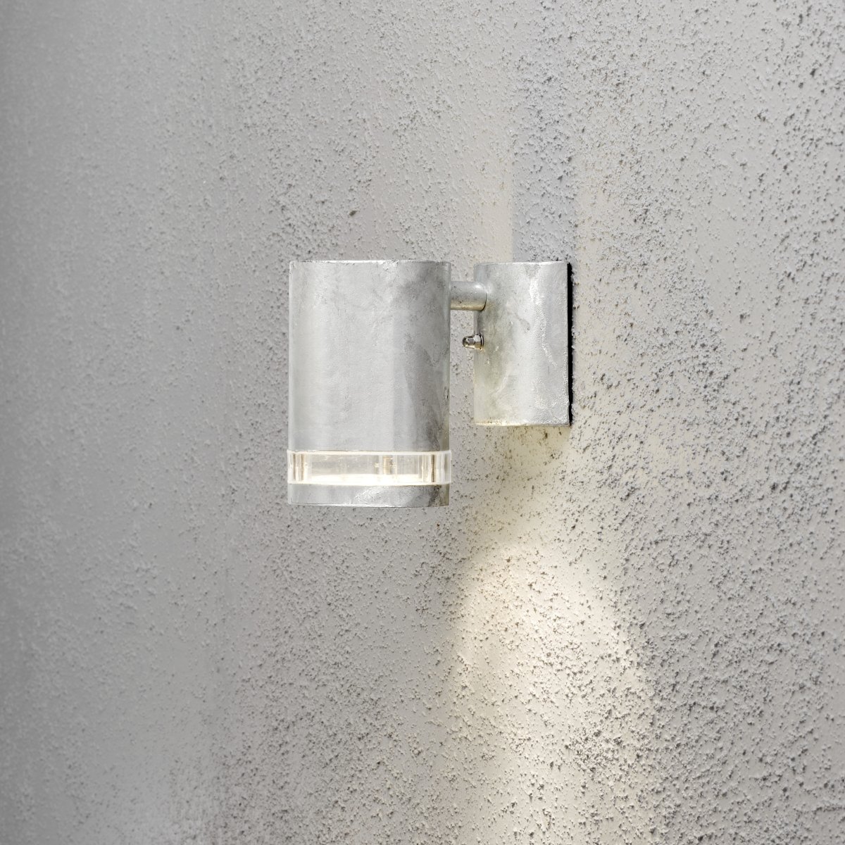 Modena Gegalvaniseerd buitenlamp Van Konstsmide - Modena is een stijlvolle gevellamp van gegalvaniseerd plaatstaal met een elegant detail van transparant acrylglas, wat de lamp een moderne uitstraling geeft.