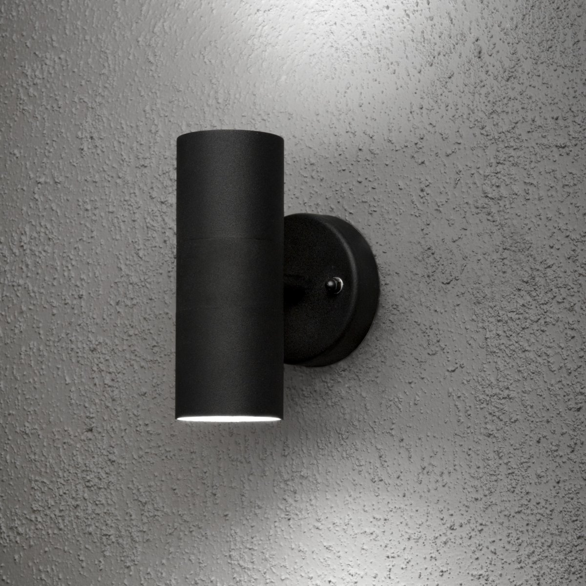 Modena Zwart buitenlamp Van Konstsmide - De lamp verspreidt het licht zowel naar boven als naar beneden en cre&euml;ert een decoratief lichtbeeld dat de gevel accentueert en een uitnodigende sfeer cre&euml;ert.
