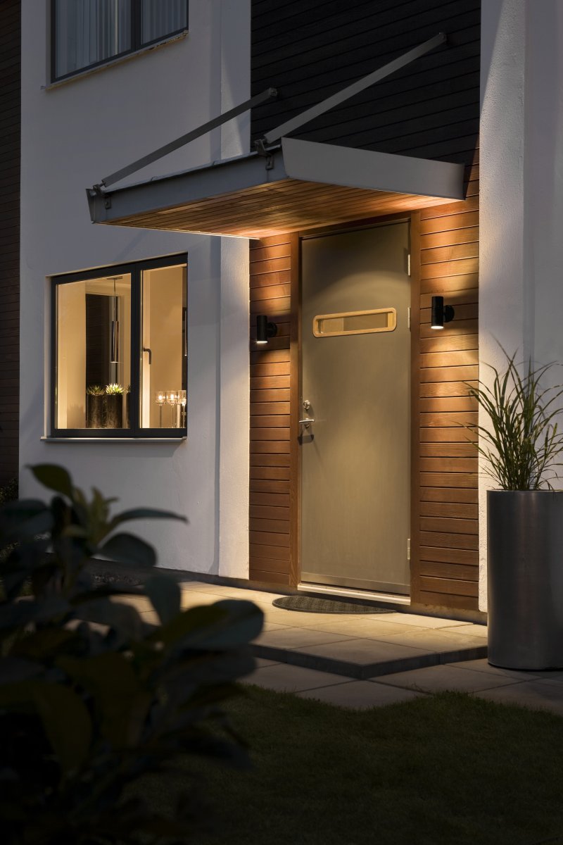 Modena Zwart buitenlamp Van Konstsmide - De lamp verspreidt het licht zowel naar boven als naar beneden en cre&euml;ert een decoratief lichtbeeld dat de gevel accentueert en een uitnodigende sfeer cre&euml;ert.