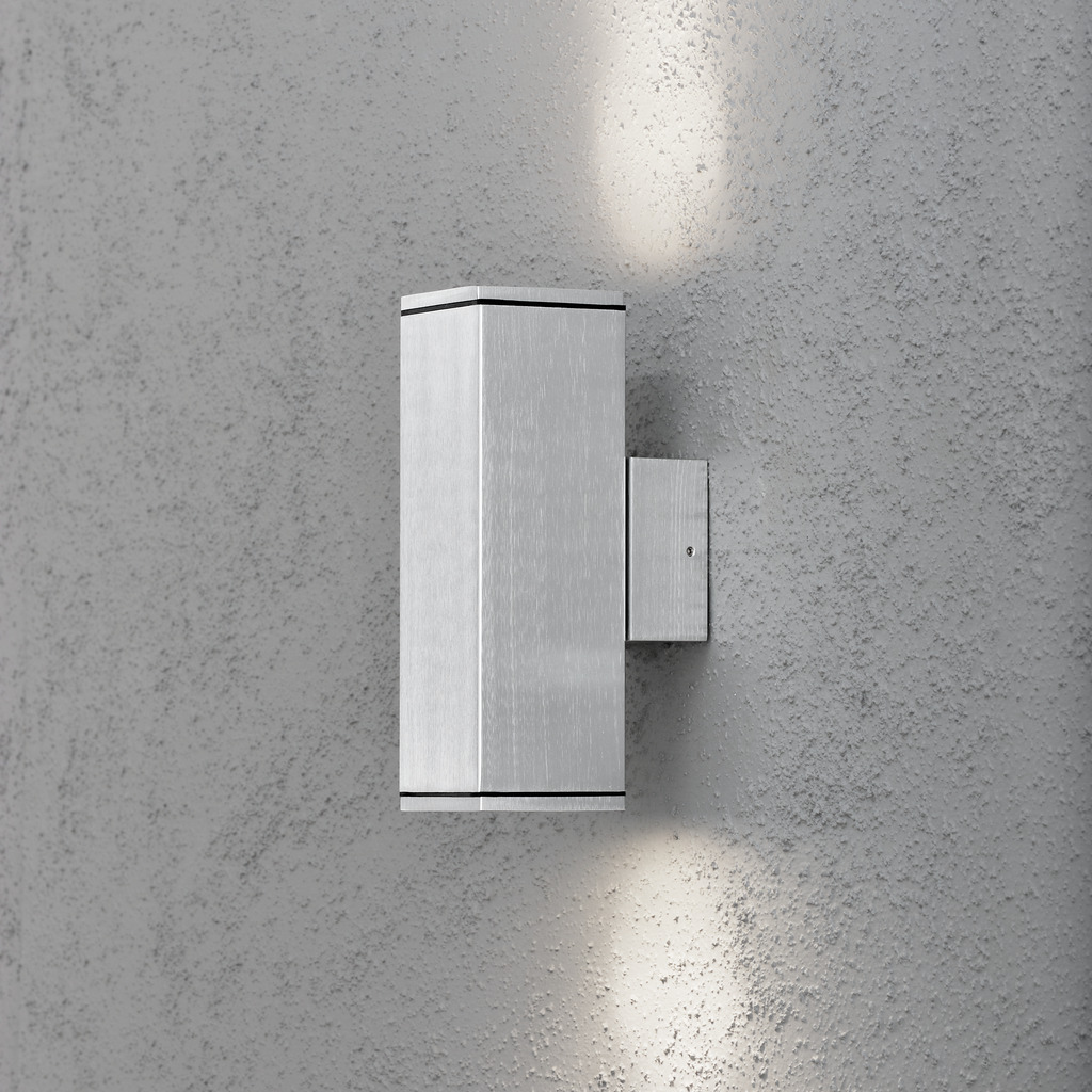 Monza Zilver buitenlamp Van Konstsmide - Het minimalistische, rechthoekige ontwerp zorgt voor een verfijnde toets en creëert een prachtig lichtspel dat de gevel accentueert.