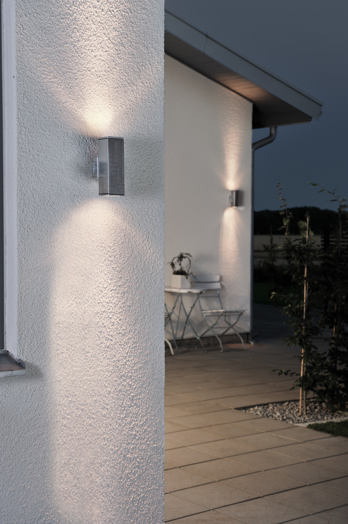 Monza Zilver buitenlamp Van Konstsmide - Het minimalistische, rechthoekige ontwerp zorgt voor een verfijnde toets en creëert een prachtig lichtspel dat de gevel accentueert.