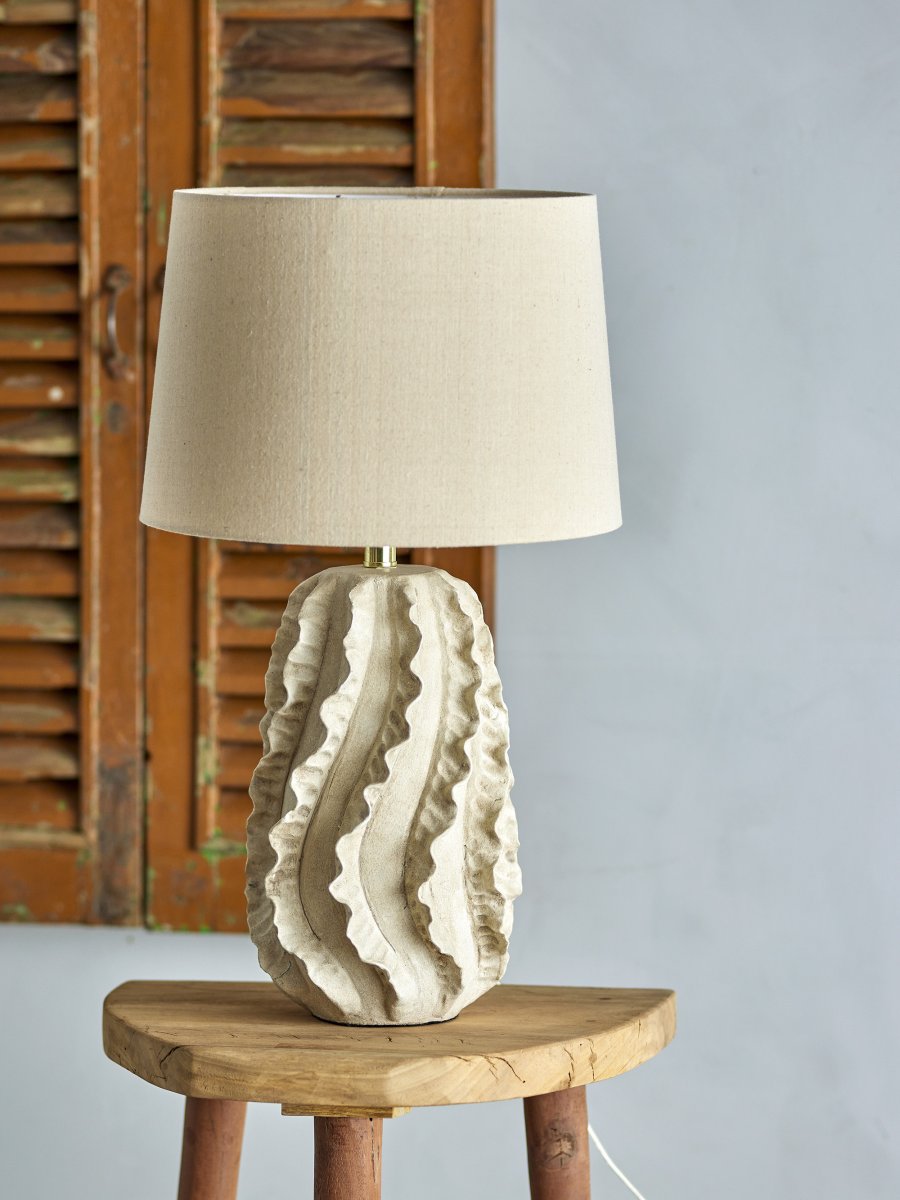 Natika 64cm Beige tafellamp Van Bloomingville - De eenvoudige witte linnen lampenkap vormt een perfecte aanvulling op de sculpturale vorm van de voet en verspreidt een aangenaam licht in de kamer.
