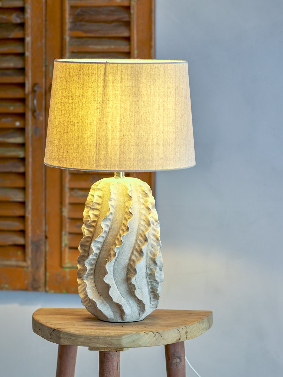Natika 64cm Beige tafellamp Van Bloomingville - De eenvoudige witte linnen lampenkap vormt een perfecte aanvulling op de sculpturale vorm van de voet en verspreidt een aangenaam licht in de kamer.