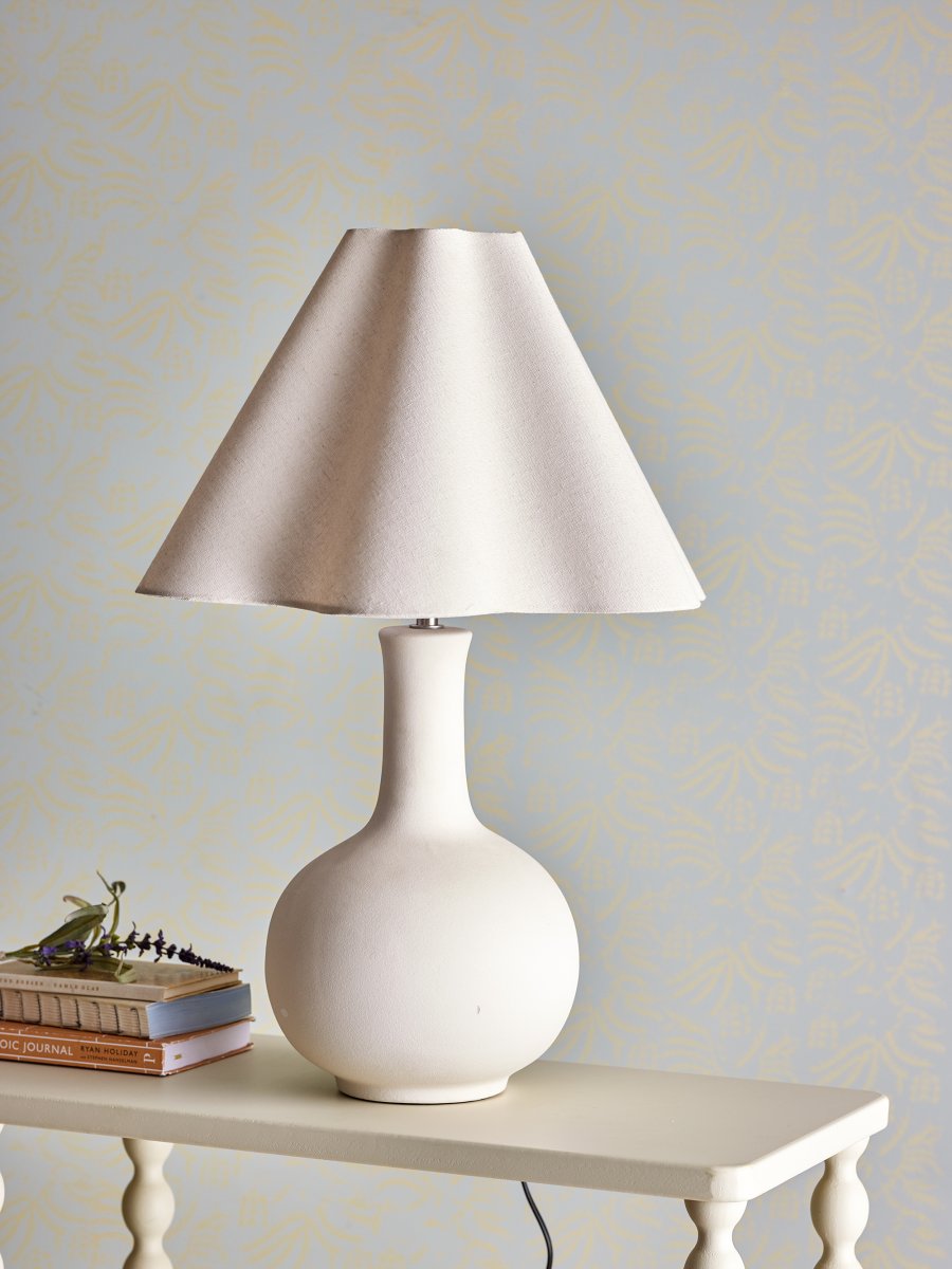 Heide 60cm Natuurlijk wit tafellamp Van Bloomingville - De ronde voet in combinatie met de zacht gebogen kap cre&euml;ert een evenwichtige en moderne uitstraling die perfect past in minimalistische en Scandinavisch ge&iuml;nspireerde woningen.