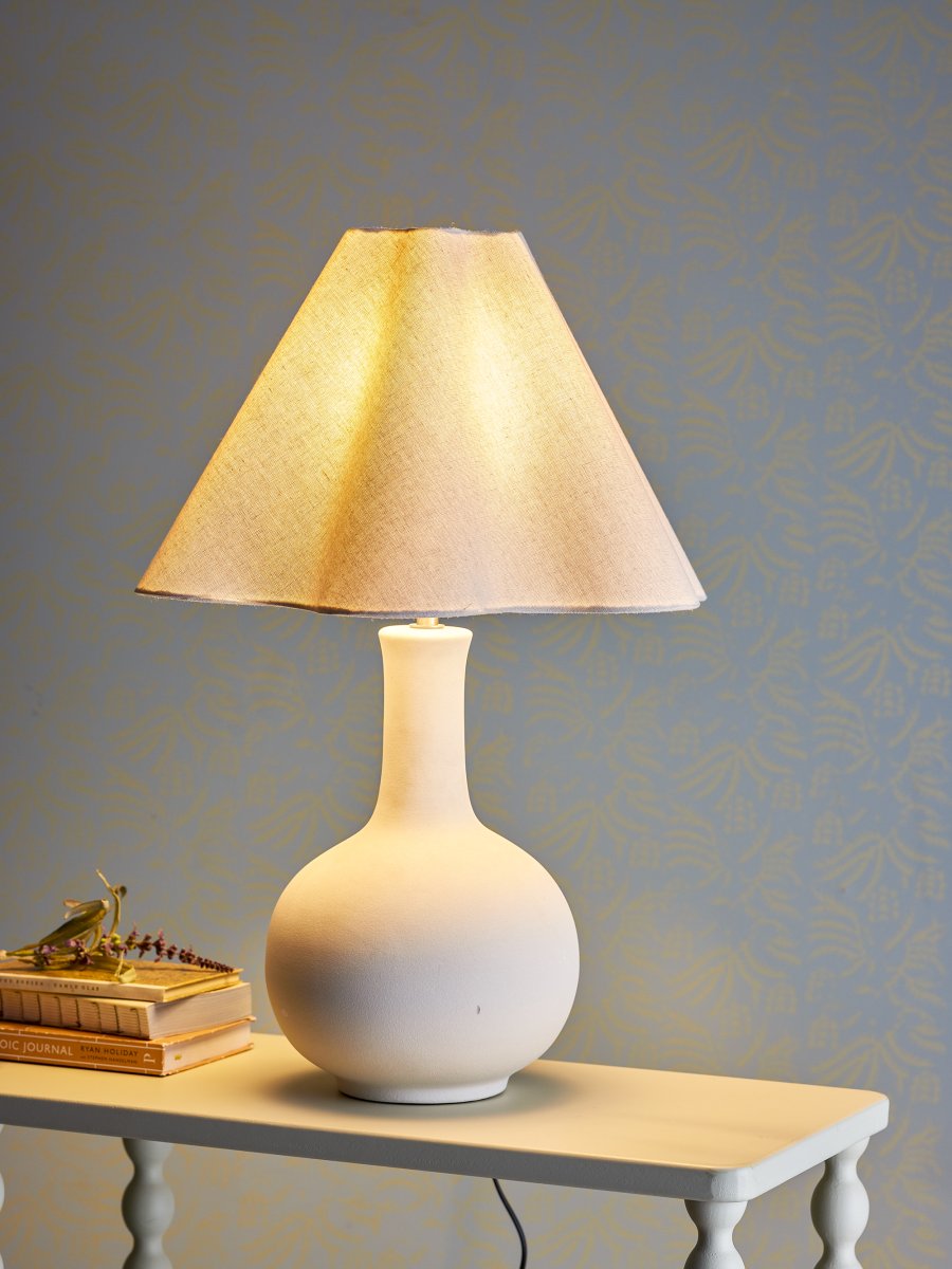 Heide 60cm Natuurlijk wit tafellamp Van Bloomingville - De ronde voet in combinatie met de zacht gebogen kap cre&euml;ert een evenwichtige en moderne uitstraling die perfect past in minimalistische en Scandinavisch ge&iuml;nspireerde woningen.