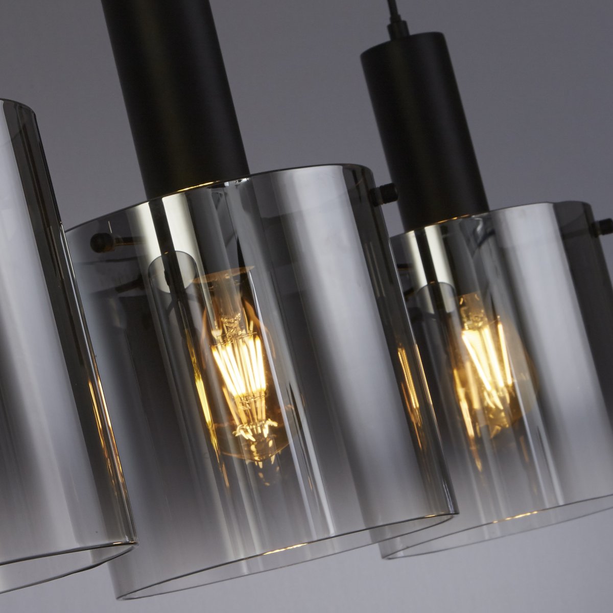 Sweden 100cm Zwart hanglamp Van Searchlight - Sweden is een stijlvolle plafondlamp met drie cilindrische koepels van zwart, licht getint glas, die een verfijnd en sfeervol licht verspreidt.