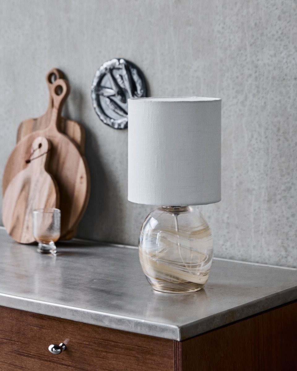 Hite 44cm Gebroken wit tafellamp Van House Doctor - De ronde glazen lampvoet is versierd met een prachtig gebroken wit wervelpatroon, waardoor elk exemplaar uniek is en de lamp een levendige uitstraling krijgt.
